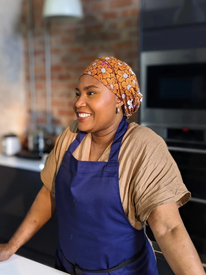 Chef Joké Bakare wearing a blue apron in the Chishuru kitchen